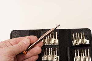 A leather purse with a screwdriver and bits. A set of different screwdrivers. photo