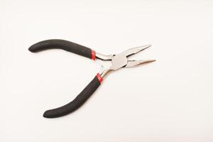 Small pliers on a white background. A tool for electronic equipment. photo