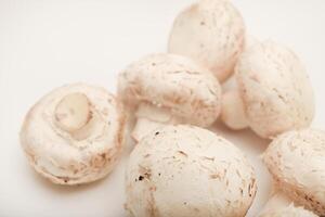Fresh champignons on a white plate. Mushrooms on a white background. photo