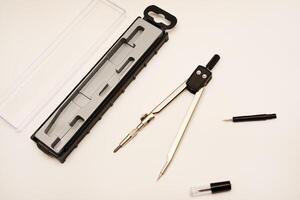 Black compasses on a white background. A drawing tool. photo