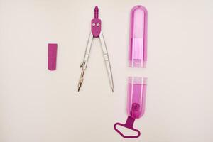 Pink compasses on a white background. A drawing tool. photo