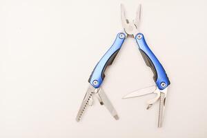 Multitool on a white background. Pocket multi-tool. Saw, knife and pliers. photo