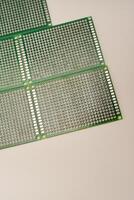 A green breadboard for electronics on a white background. Printed circuit boards for mounting radio elements. photo