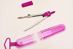 Pink compasses on a white background. A drawing tool. photo