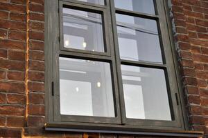 Classic windows in a brick house. Beautiful black windows in the house. photo