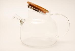 Glass teapot with wooden lid on a white background. photo