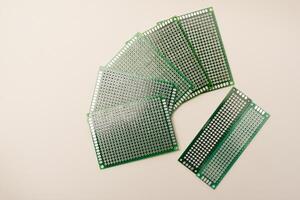 A green breadboard for electronics on a white background. Printed circuit boards for mounting radio elements. photo