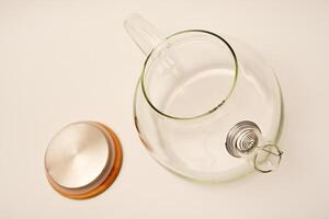 Glass teapot with wooden lid on a white background. photo