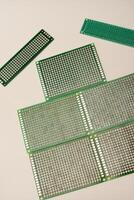 A green breadboard for electronics on a white background. Printed circuit boards for mounting radio elements. photo