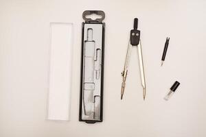 Black compasses on a white background. A drawing tool. photo