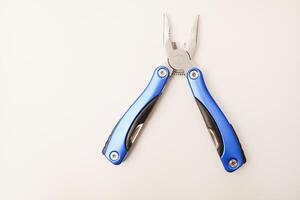 Multitool on a white background. Pocket multi-tool. Saw, knife and pliers. photo