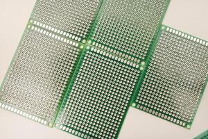A green breadboard for electronics on a white background. Printed circuit boards for mounting radio elements. photo