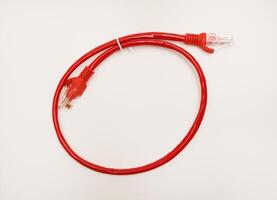 Red internet cable on a white background. The RJ-45 connector. photo
