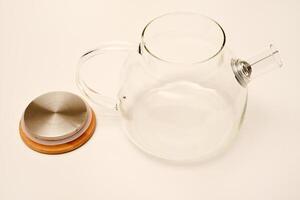 Glass teapot with wooden lid on a white background. photo