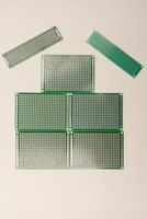 A green breadboard for electronics on a white background. Printed circuit boards for mounting radio elements. photo