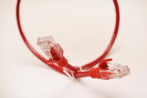 Red internet cable on a white background. The RJ-45 connector. photo