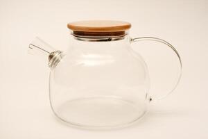 Glass teapot with wooden lid on a white background. photo