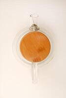 Glass teapot with wooden lid on a white background. photo