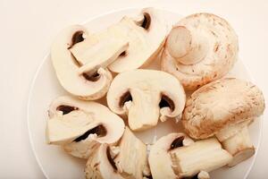 Fresh champignons on a white plate. Mushrooms on a white background. photo