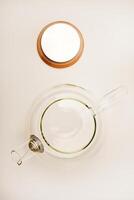Glass teapot with wooden lid on a white background. photo