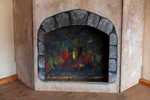 Cozy fireplace with vibrant artwork resembling flames in a rustic interior setting photo