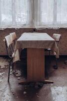 Abandoned dining area with worn-out furniture and dusty atmosphere in an old building photo