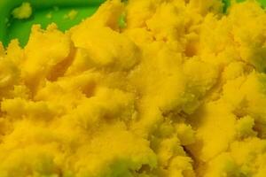 Bright yellow dessert preparation in a vibrant kitchen setting with focus on texture and color during the daytime photo