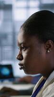 Vertical Close up of programmer in data center implementing AI predictive maintenance systems. Focus on IT professional in server hub using artificial intelligence to identify hardware failures, camera A video