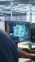 Vertical African american worker in data center implements advanced AI driven predictive maintenance systems. Engineer using artificial intelligence to identify hardware failures impacting operations, camera A video
