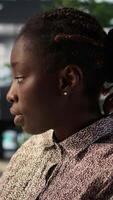 Vertical African american female analyst works at desk in a corporation, working on financial forecasting and business strategy. Expert focuses on company growth with resource allocation. Camera B. video