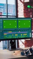 editor wearing headphones to polish footage and improve audio quality on green screen PC. Videographer professionally adjusting clips, applying sound effects using chroma key computer, camera A video