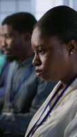 Vertical African american data center technicians implement AI predictive maintenance systems. Woman in server hub using artificial intelligence to identify hardware failures, camera A video