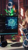AI software developer at computer waiting for code to finish compiling, rubbing forehead with pen, feeling bored. Impatient man waits for artificial intelligence scripts to finish compiling, camera B video