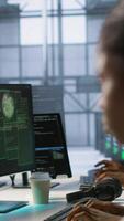 Vertical Cybersecurity specialists in server room trying to protect equipment from hacker stealing data. Programmers in data center office doing teamwork to delete virus attacking company servers, camera A video