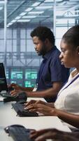 Vertical IT staff members seeing critical error popup on PC screen in data center, requesting help from cybersecurity team. Server hub coworkers struggling to eliminate cyberattacks affecting network, camera A video