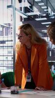 Vertical General director reviewing data analytics with her team for successful development plan, working to expand the enterprise globally. Female CEO showing great leadership skills in a meeting. Camera B. video