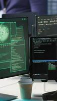 Vertical Programmer seeing red critical error popup on computer display in data center, panicking. African american man in server hub spamming keyboard buttons after receiving error, camera A video