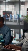 Vertical Black coworkers collaborating on investment strategy with data on files, CEO and assistant with extensive expertise to work on decision making. Administrative tasks in the office. Camera A. video