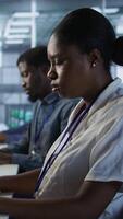 Vertical Close up of programmer in data center implementing AI predictive maintenance systems. Focus on IT professional in server hub using artificial intelligence to identify hardware failures, camera A video