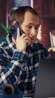 Manager at work arguing with employee during phone call after finding mistakes in spreadsheets on laptop. Team leader scolding worker during telephone call after finding errors in documents, camera B video