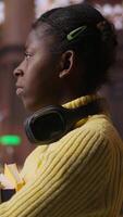 Vertical Portrait of african american scholar arriving at the library with her learning materials and books, holding textbooks with class notes to the study area. Pupil studying to pass her exams. Camera B. video