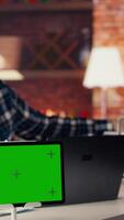 Green screen tablet next to man using laptop, answering phone call while checking emails displayed on screen. Mockup device next to worker in telephone call with friend at work, camera B video
