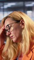 Vertical General manager in a briefing meeting feeling sick and anxious, strategizing for corporate success with a headache. Empowered woman leader being overwhelmed and tired under pressure. Camera A. video