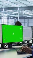 Vertical Engineer using green screen computer in server room, developing disaster recovery plans ensuring minimal downtime. Data center worker looking at mockup PC, monitoring performance, camera A video