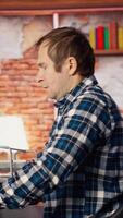 Coder at workstation programming on PC, writing lines of code, using development tools, feeling stressed. Man in home office having deadline, stressed to finish debugging software, camera B video