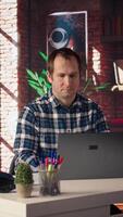 Freelancer in home office sitting at desk and typing on laptop keyboard. Remote employee using electronic device to do customers relations job online, answering inquiries, camera A video