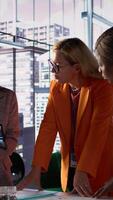 Vertical Multiethnic women executives uniting forces in a collaborative meeting, focused on data management and business development. Experts with leadership skills fighting for empowerment. Camera B. video