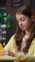 Vertical Young teen girl engrossed in reading books at the school library, focusing on literature and knowledge while she is preparing for her academic lessons and other class assignments. Camera B. video