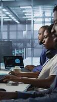 Vertical Admin in data center drinking coffee and implementing AI predictive maintenance systems. Server hub worker enjoying hot beverage, using artificial intelligence to identify hardware failures, camera A video