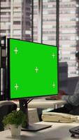 Vertical Female director seated at workstation with green screen on devices, working on solving administrative tasks for enterprise growth. Performance metrics to support project objectives. Camera B. video